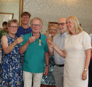 Wethouder Van Werven heft een glas drinken, samen met decorandus Peter van der Vlist en genodigden