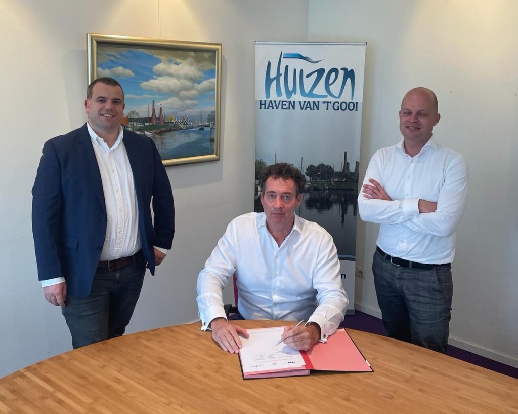 De ondertekening van de contractovername van de Oude Haven Fase 3 door wethouder Roland Boom van de gemeente Huizen, directeur Sjuul Stappers van Verwelius en Michiel de Vries van VORM.