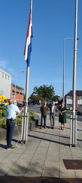 burgemeester Niek Meijer, wethouder Fleur van der Kleij en Mohamed Azaghouli, bestuurslid van An-Nasr, de Marokkaanse Moskee in Huizen, kijken naar de Nederlandse vlag die half stok hangt.