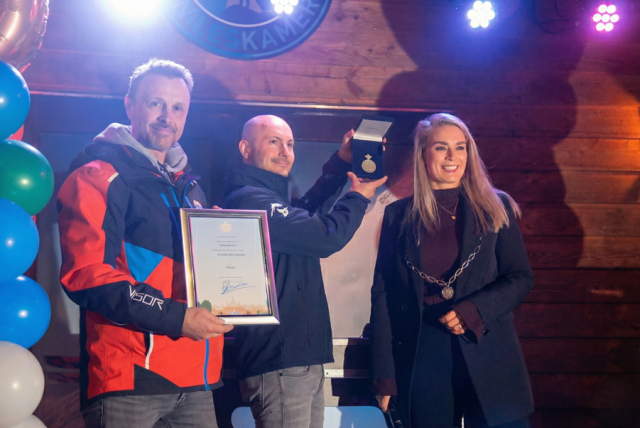 Wethouder Fleur van der Kleij overhandigt de Huizer erepenning aan het bestuur van Skiclub Wolfskamer.