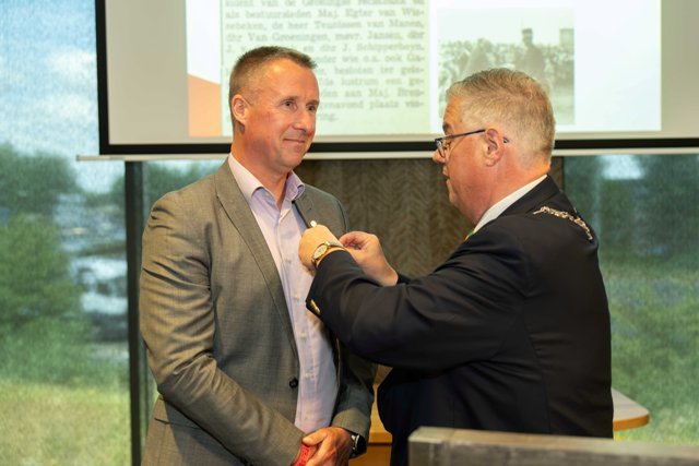 Burgemeester Bruls van gemeente Nijmegen plaatst de erepenning op het jacquet van de heer Leijtens