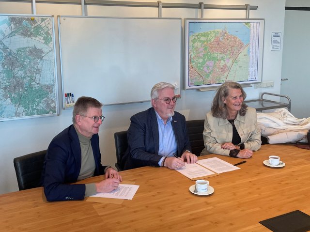 Wethouder Bert Rebel en Agnes Haverkort, Eduard Rebel vanuit de Stichting Ondernemersfonds ‘t Hart van Huizen ondertekenen de uitvoeringsovereenkomst voor de bedrijveninvesteringszone.