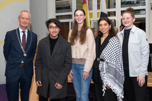 Burgemeester Niek Meijer samen met Doryoosh Faqiri, Anouk Verlaan, Ilayda Tapan en Esmee Duim van het Jongerenpanel Huizen.