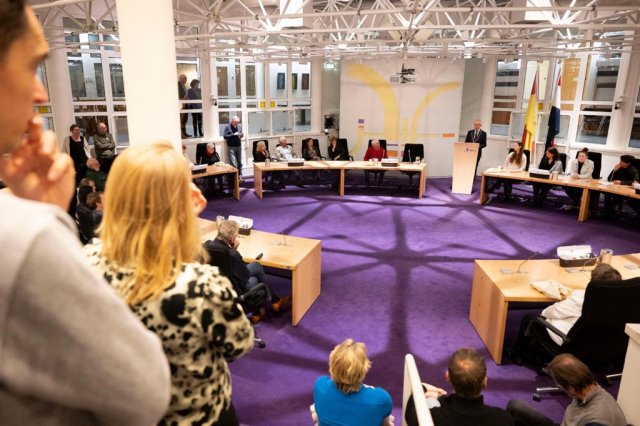 Jongeren stellen zich in de raadszaal van gemeente Huizen voor tijdens nieuwjaarsreceptie