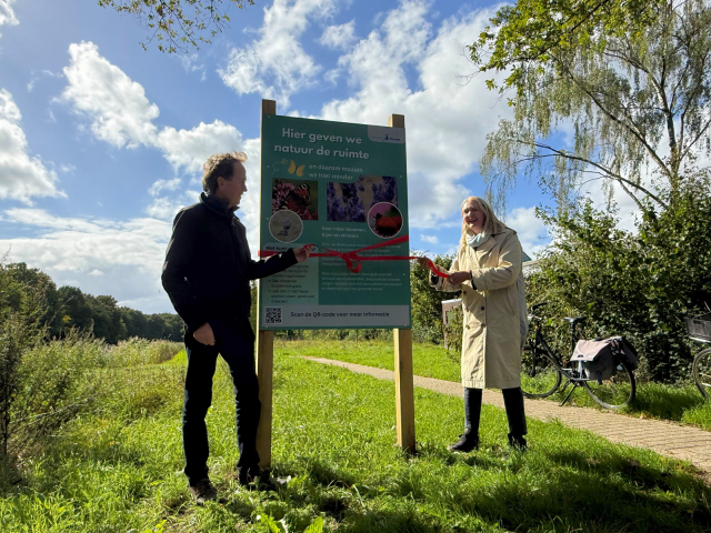 Wethouder Karin van Werven en Hugo Weenen (van de Expertgroep Natuur) onthullen het informatiebord maaibeheer