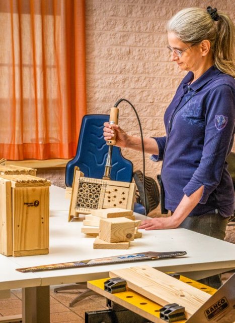 Een vrouw maakt een insectenhotel op het Talentenplein bij Promen