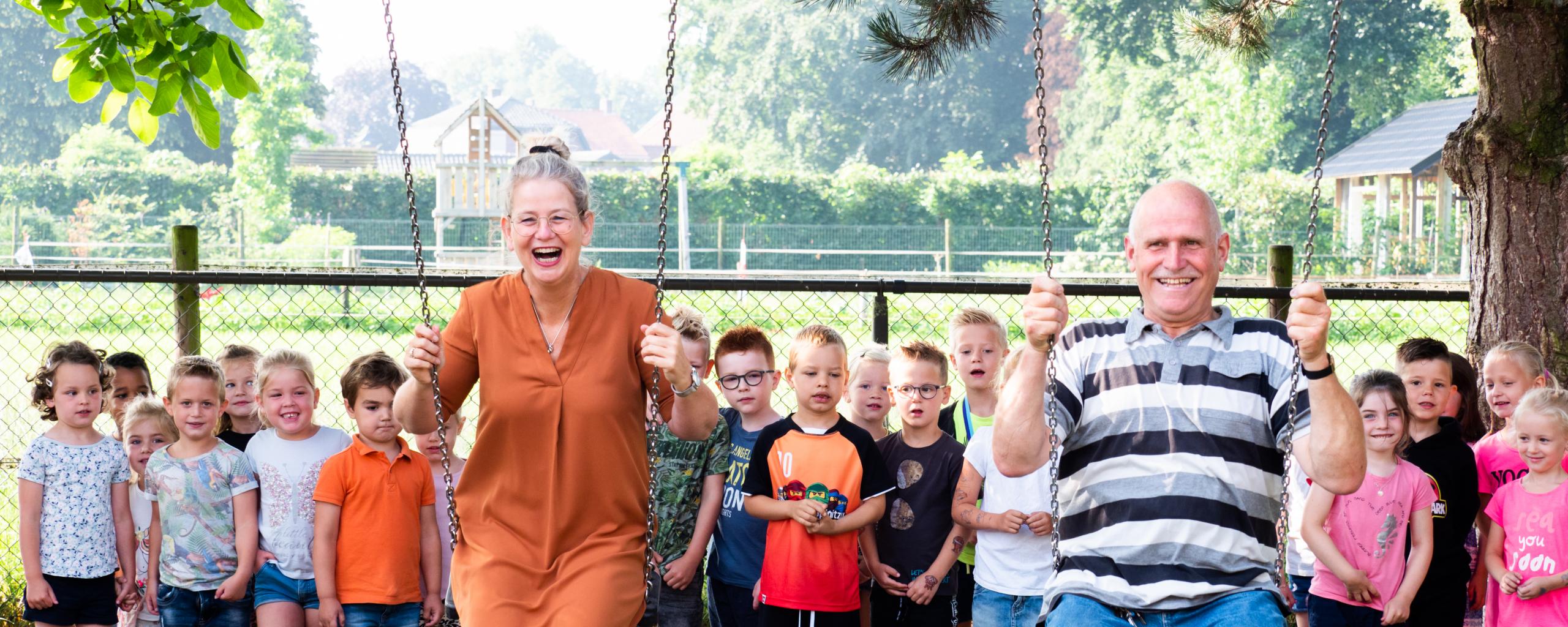 Foto van werkgever en werknemer op schommel basisschool