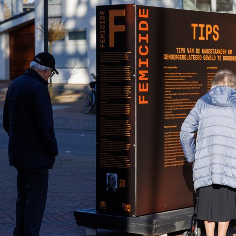 Twee personen lezen de tekst en kijken naar het portret