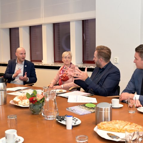 Hugo de Jonge aan tafel in gesprek met burgemeester Dassen en wethouder Weijers.