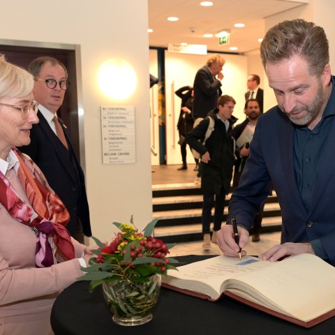 Minister Hugo de Jonge tekent het gastenboek van Kerkrade op het Raadhuis.