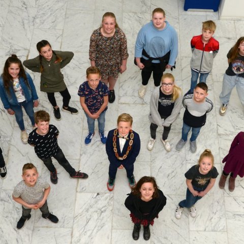 Members of the children's council stand in the hall of the council house and look up into the camera