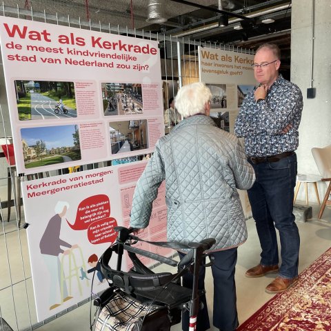 Twee personen in gesprek voor een presentatiebord over de omgevingsvisie