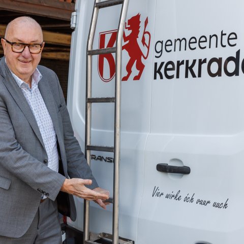 Wethouder Schlangen wijst naar de slogan