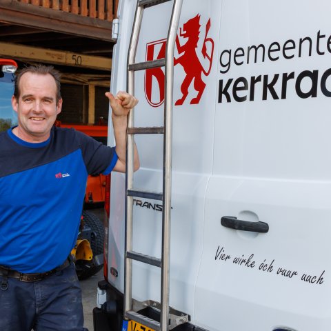 Buitenmedewerker naast de bus