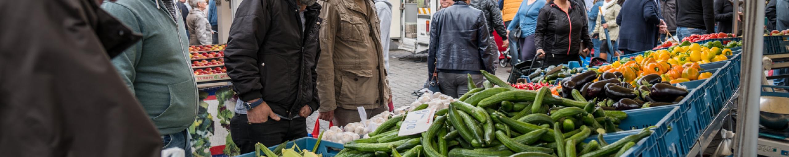 Mensen bij een marktkraam met groenten