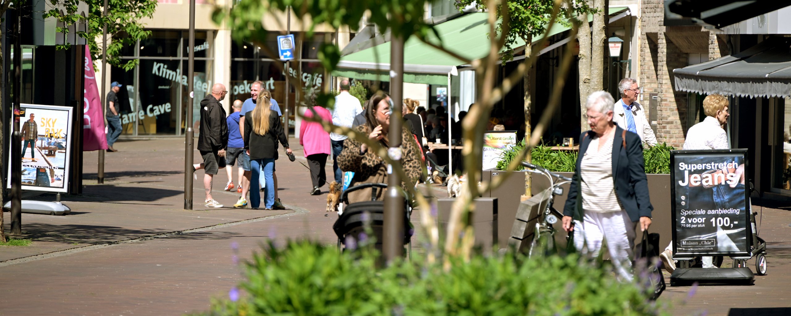 A photo taken in Kerkrade's Hoofdstraat. The photo shows visitors to the city center and trees. 