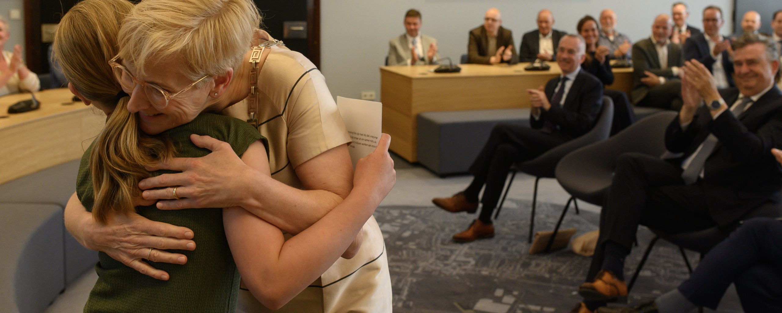 Burgemeester Petra Dassen-Housen omhelst kinderburgemeester Jinte Brandts in een gevulde raadszaal