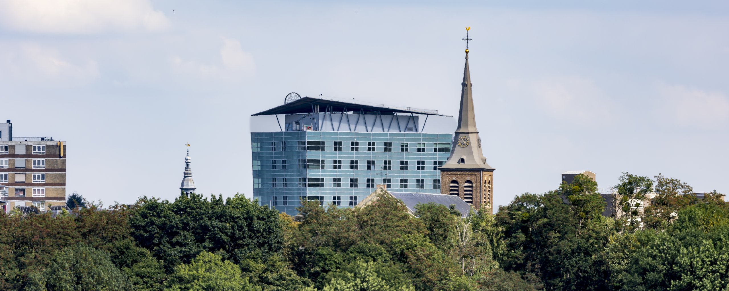 De skyline van het centrum: Lamburtuskerk en stadskantoor boven de bomen