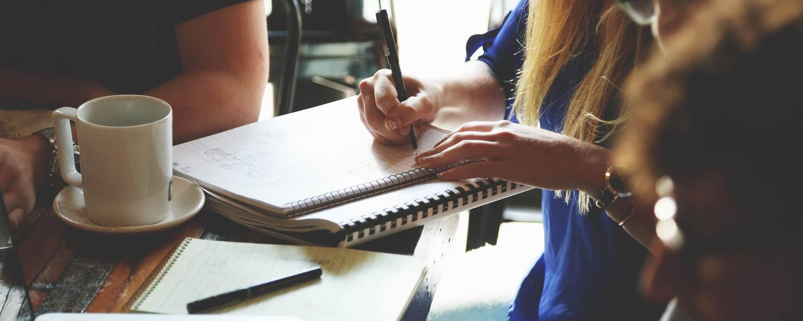 Werkende mensen in een team aan tafel, informeel.