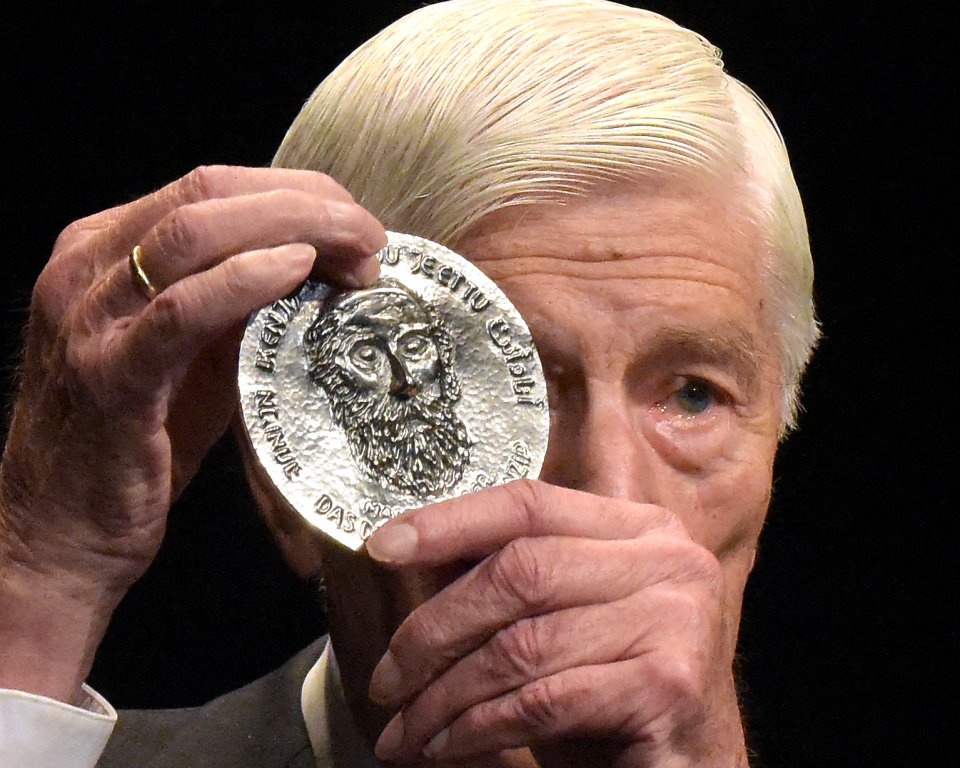 Dries van Agt holds up the Buber plaque in front of his face