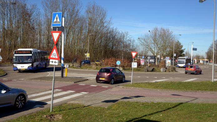 Rotonde richting Heerlerbaan bij busstation Locht-Roda, blauwe lucht, twee bussen en drie auto's