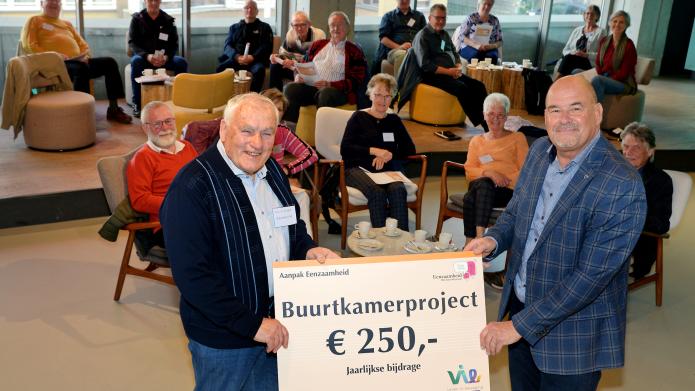 Wethouder Leo Jongen (rechts) overhandigt in de foyer van de HUB symbolisch het bedrag van 250 euro aan Herman Vleugels, voorzitter van de Buurtkamer Norbertushof. 