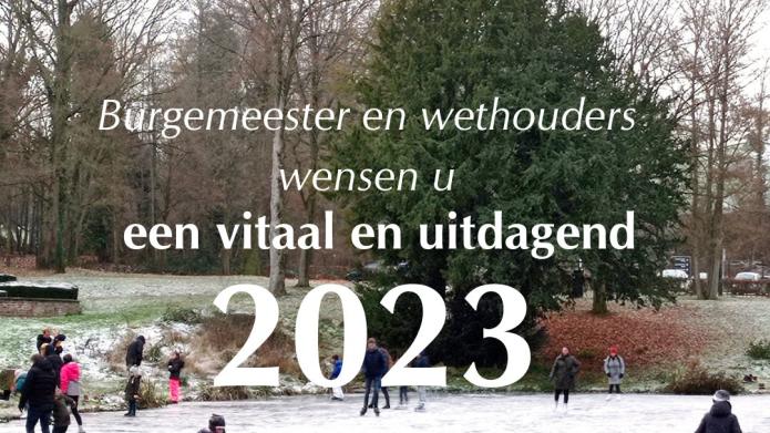 Een beeld van schaatsende mensen op de vijver van Kasteel Erenstein met in wit de tekst Burgemeester en wethouders wensen u een vitaal en uitdagend 2023