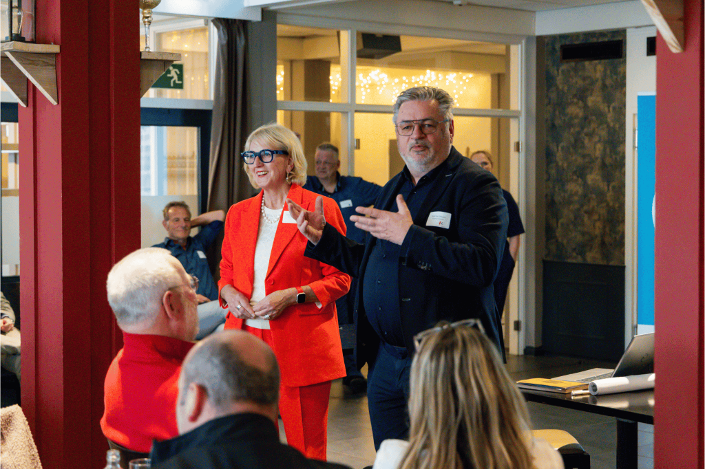 Wethouder René van Drunen staat voor een groep mensen en vertelt iets