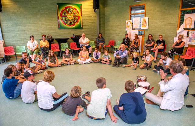 Leerlingen van de zomerschool zitten samen in de kring. 