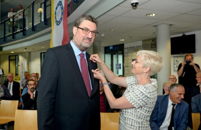 Burgemeester Dassen-Housen speldt de onderscheiding op bij de heer Von den Driesch.