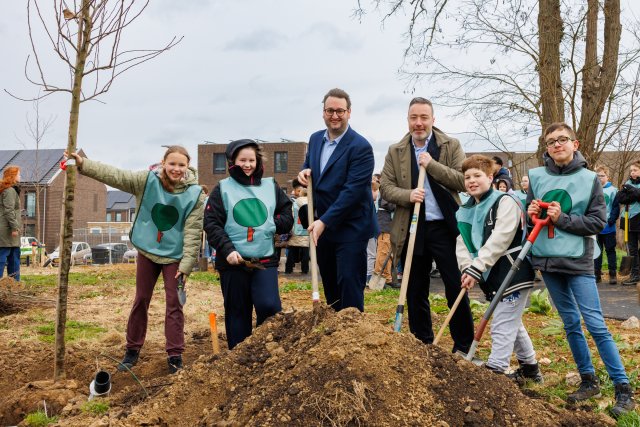 Kinderen van basisscholen St. Ursula en De Blokkenberg, gedeputeerde Marc van Caldenberg en wethouder Alexander Geers poseren met een schop in handen voor de foto voordat ze aan de slag gaan met het planten van de eerste boom 