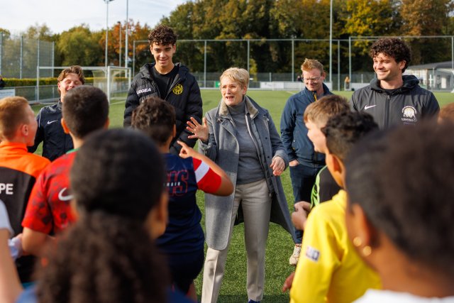 Burgemeester Petra Dassen spreekt de scholieren toe op voetbalveld