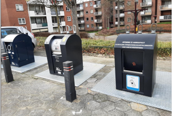 Drie ondergrondse containers v.l.n.r. voor glas, restafval en papier. Op de achtergrond laagbouwflats