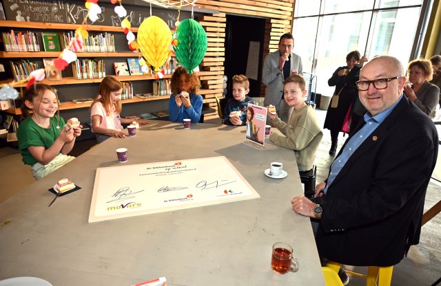 Wethouder Schlangen viert de Bibliotheek op school met enkele leerlingen van basisschool De Diabolo.