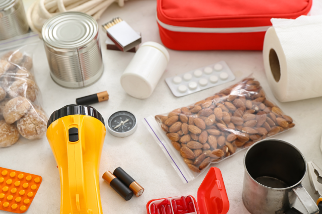 De inhoud van een noodpakket: verbandtasje, zaklamp, batterijen, lucifers, tabletten, toiletpapier, blik, kompas