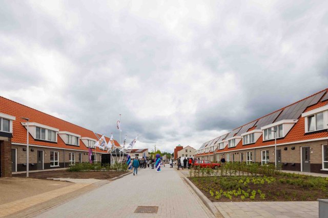 Een foto vanuit het midden van de straat met aan beide zijden nieuwbouwhuizen.