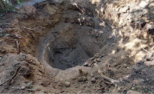 Foto van graafwerkzaamheden bij schacht Beerenbosch 1. Er is een cirkelvormige muur in de grond te zien. 