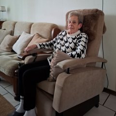Mevrouw Elzinga in haar stoel in de woonkamer.