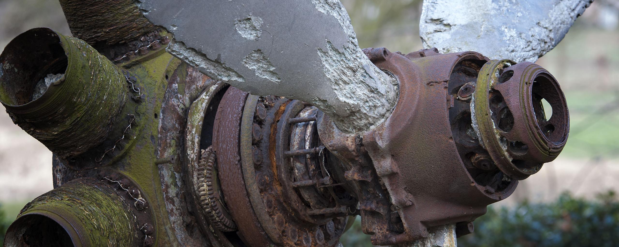 Een oude, roestige en gedeukte propeller van een vliegtuig. De propeller staat in Herkenbosch en maakt deel uit van een herdenkingsmonument voor slachtoffers van een vliegtuigondelijk tijdens de tweede wereldoorlog.