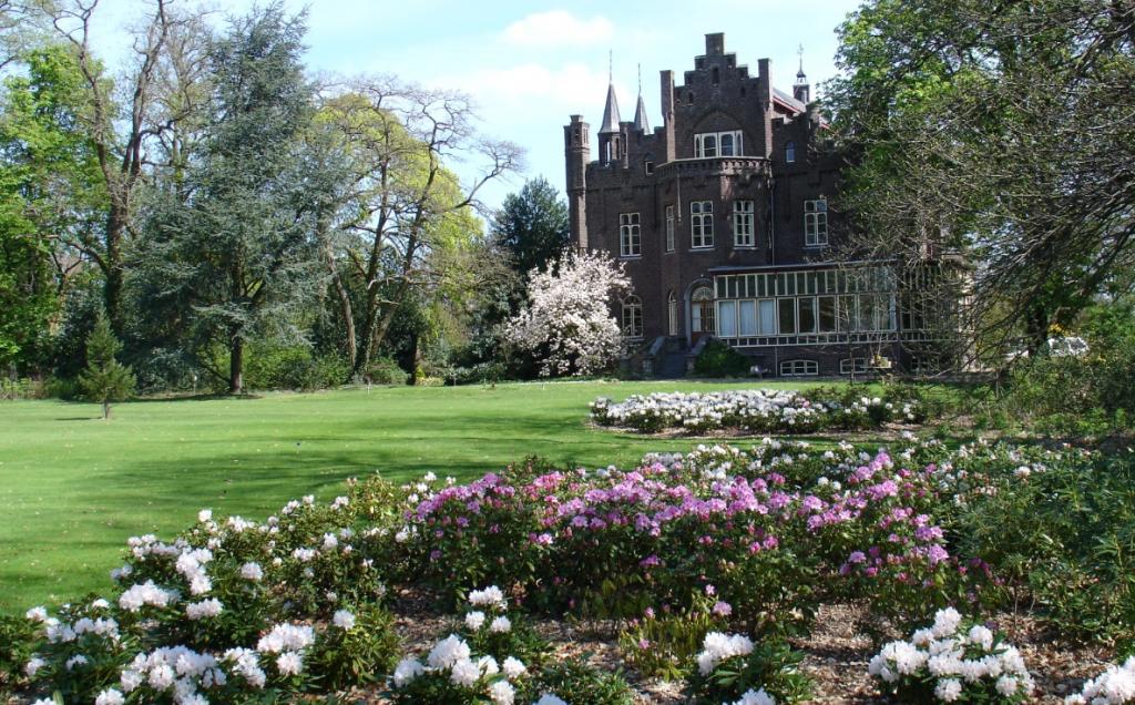 Kasteel Aerwinkel met bloeiende bloemen op de voorgrond.