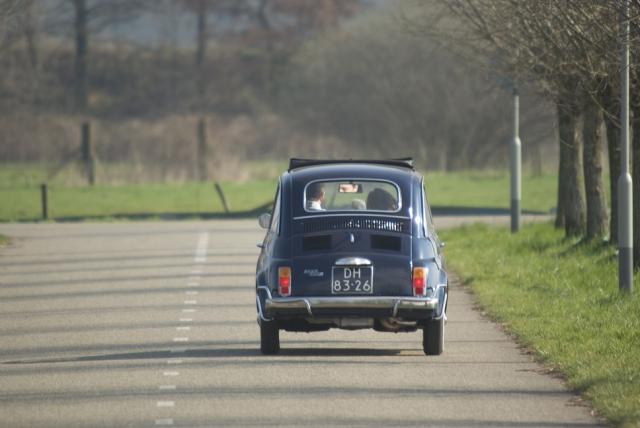 Een oldtimer mini rijdt over de weg
