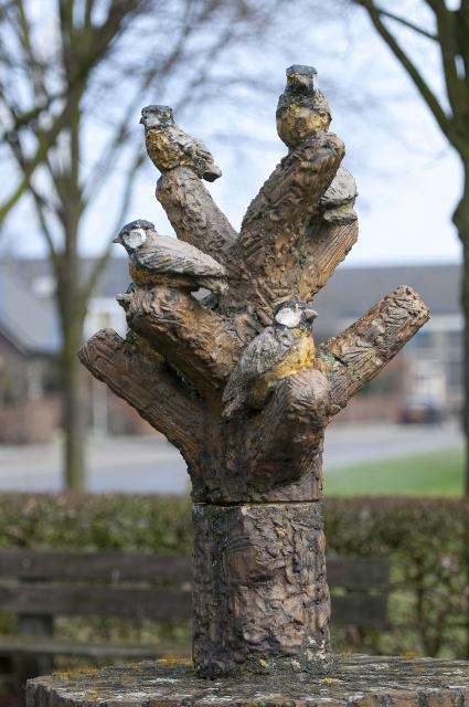 Een kunstwerk in de vorm van een boom met vijf vogels op de takken. Dit is het carnavalsbeeld in Posterholt.
