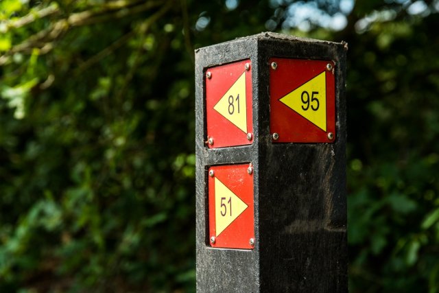 Een routepaaltje met daarop verschillende routes aangegeven.