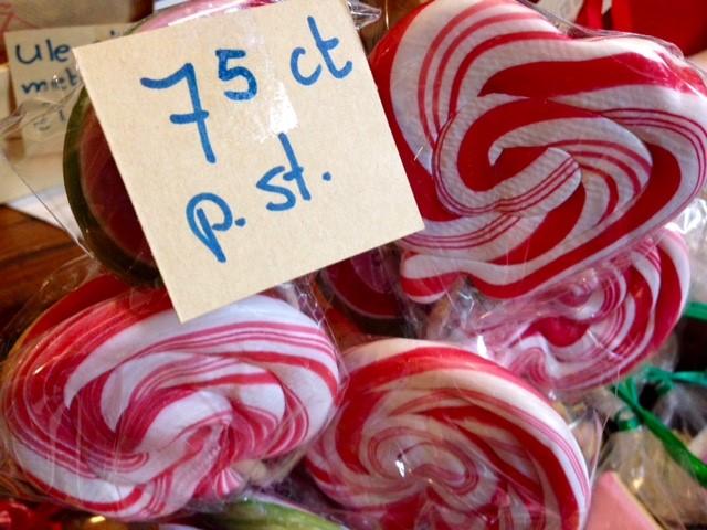 We zien grote rood met witte lolly's en een handgeschreven prijskaartje. De foto is gemaakt in het snoepwinkeltje in Posterholt.