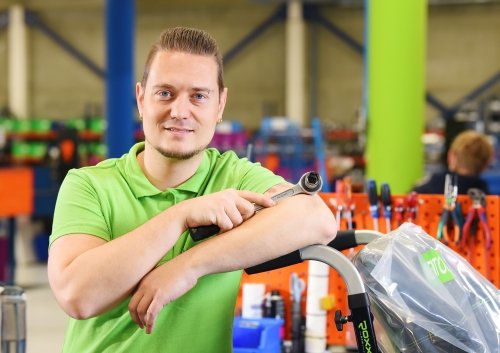 Man met groen shirt op de werkvloer