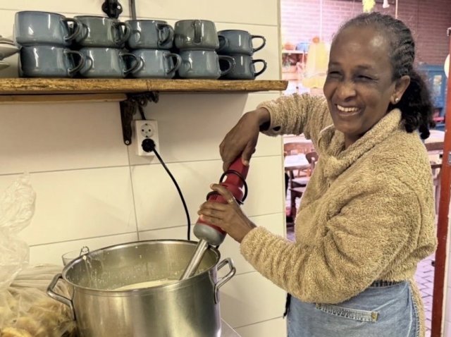 Een vrouw die in een keuken in een pan staat te roeren