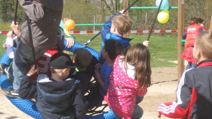 kinderen spelen op een grote schommel in een speeltuin