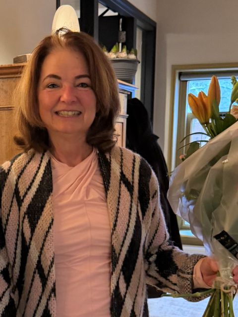 Persoon in een roze gestreepte outfit poseert