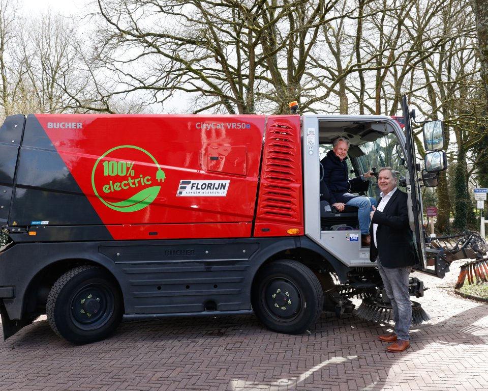 Elektrische veegwagen op straat met 2 personen bij het voertuig.