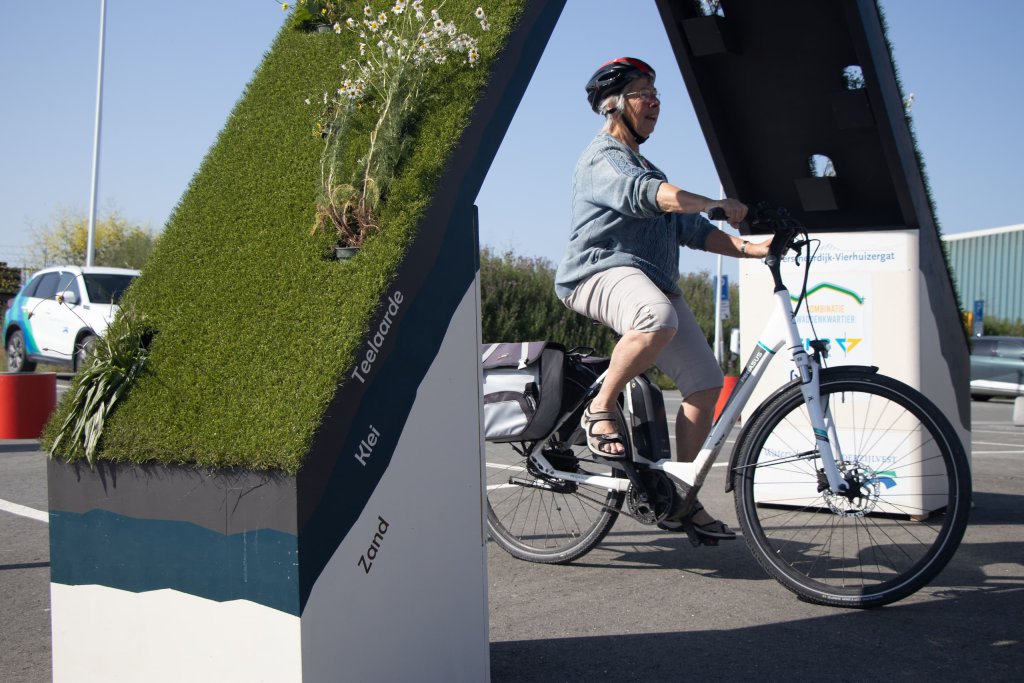 Een bezoeker van de Dag van de Bouw fietst onder de groene boog door
